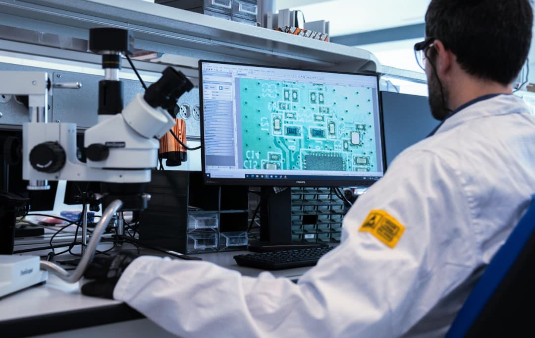 Technician reviewing PCB diagnostic imaging on a lab workstation monitor